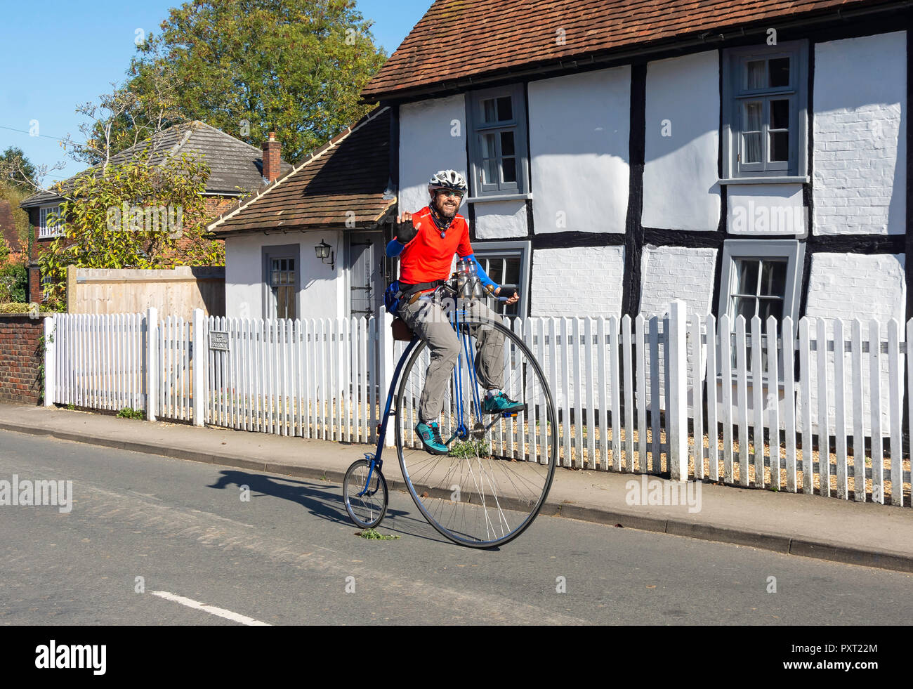 Man riding period penny-farthing bicycle, The Street, Shurlock Row, Berkshire, England, United Kingdom Stock Photo