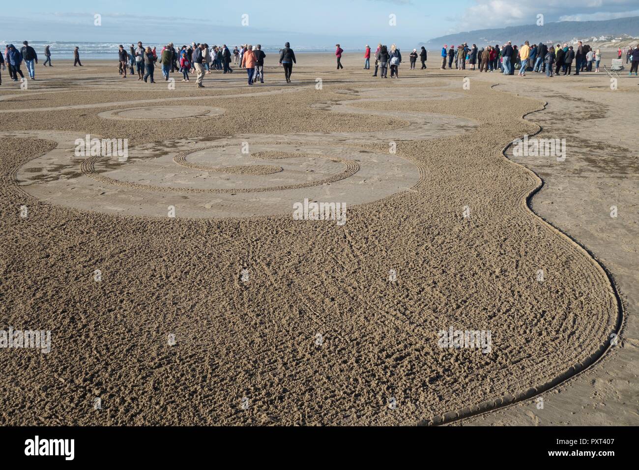 People walking a sand labyrinth, created by Denny Dyke of Circles in the Sand, in Florence, Oregon, USA. Stock Photo