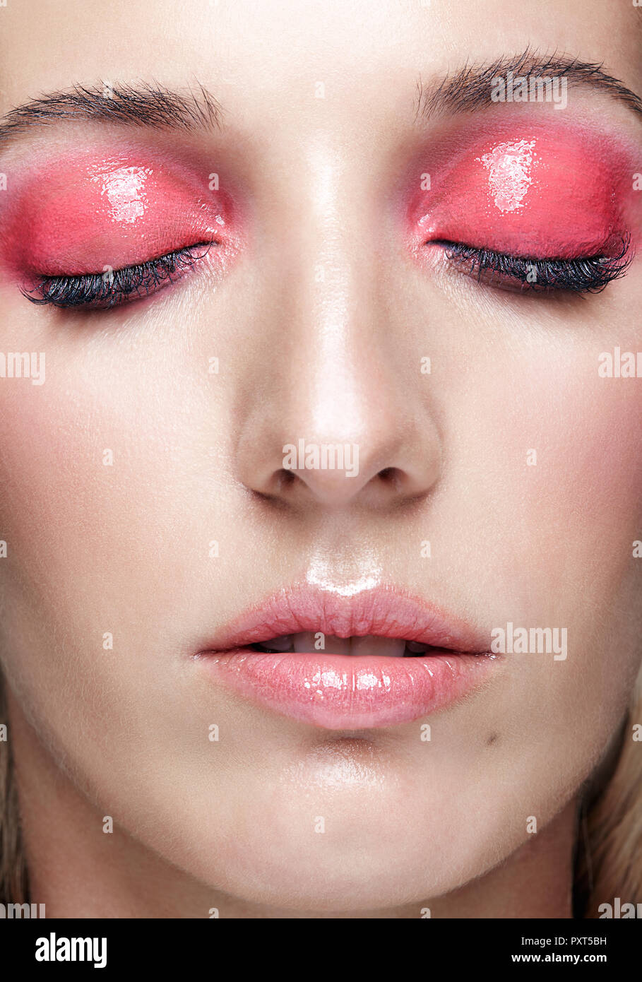 Closeup macro shot of female face and pink smoky eyes beauty makeup. Woman with glossy glitter white skin. Stock Photo