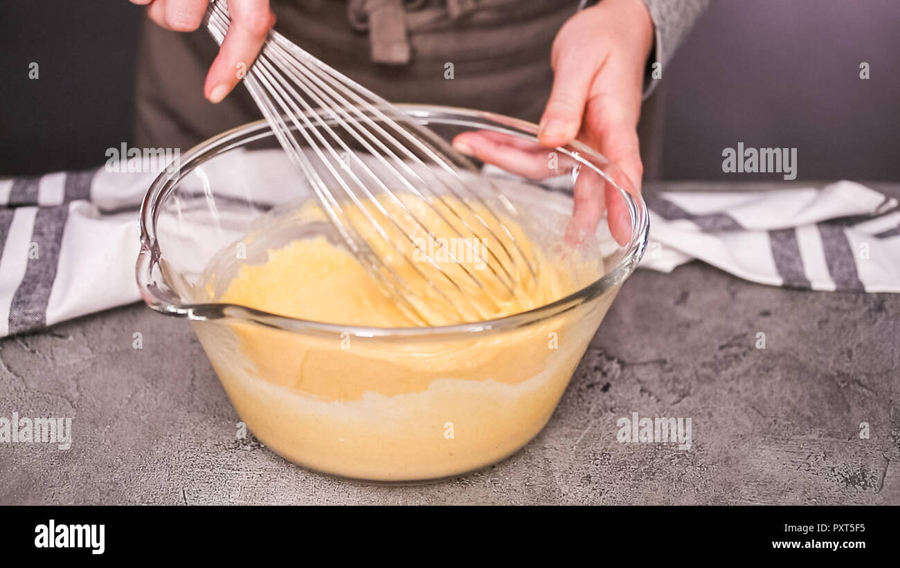 Step by step. Mixing ingredients together in glass mixing bowl for