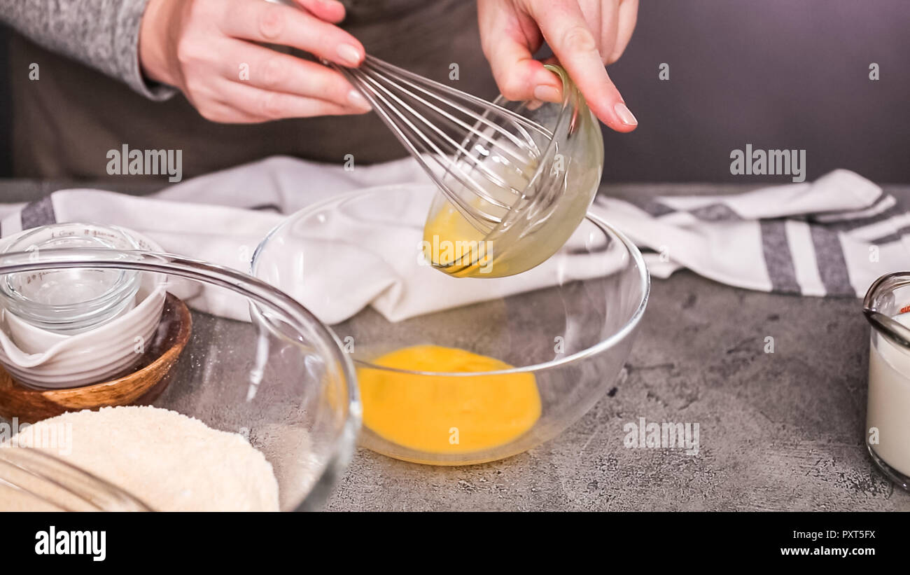 Step by step. Mixing ingredients together in glass mixing bowl for