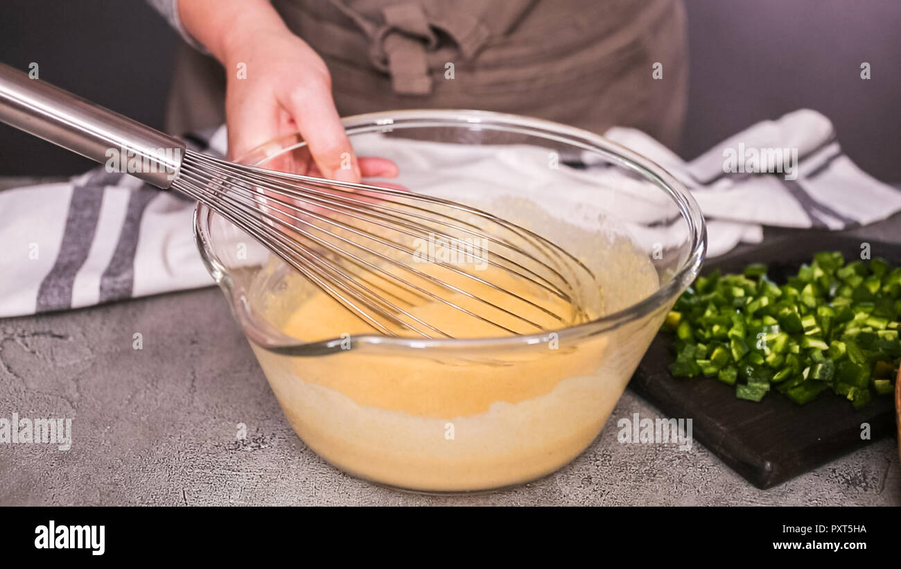 Step by step. Mixing ingredients together in glass mixing bowl for