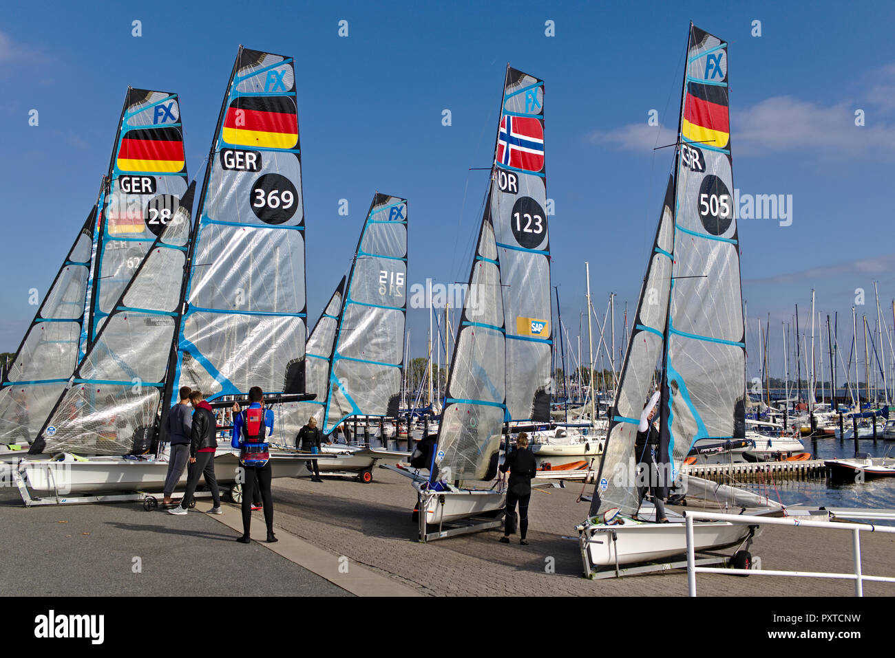 Kiel, Germany - September 9th, 2018 - Several 49er FX dinghies on the shore with their crew after training Stock Photo