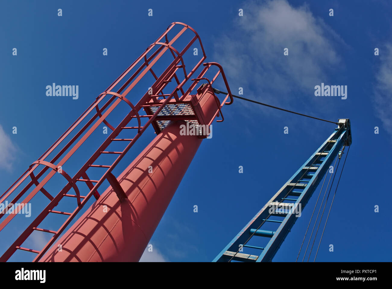 Red and blue boat crane with blue sky Stock Photo