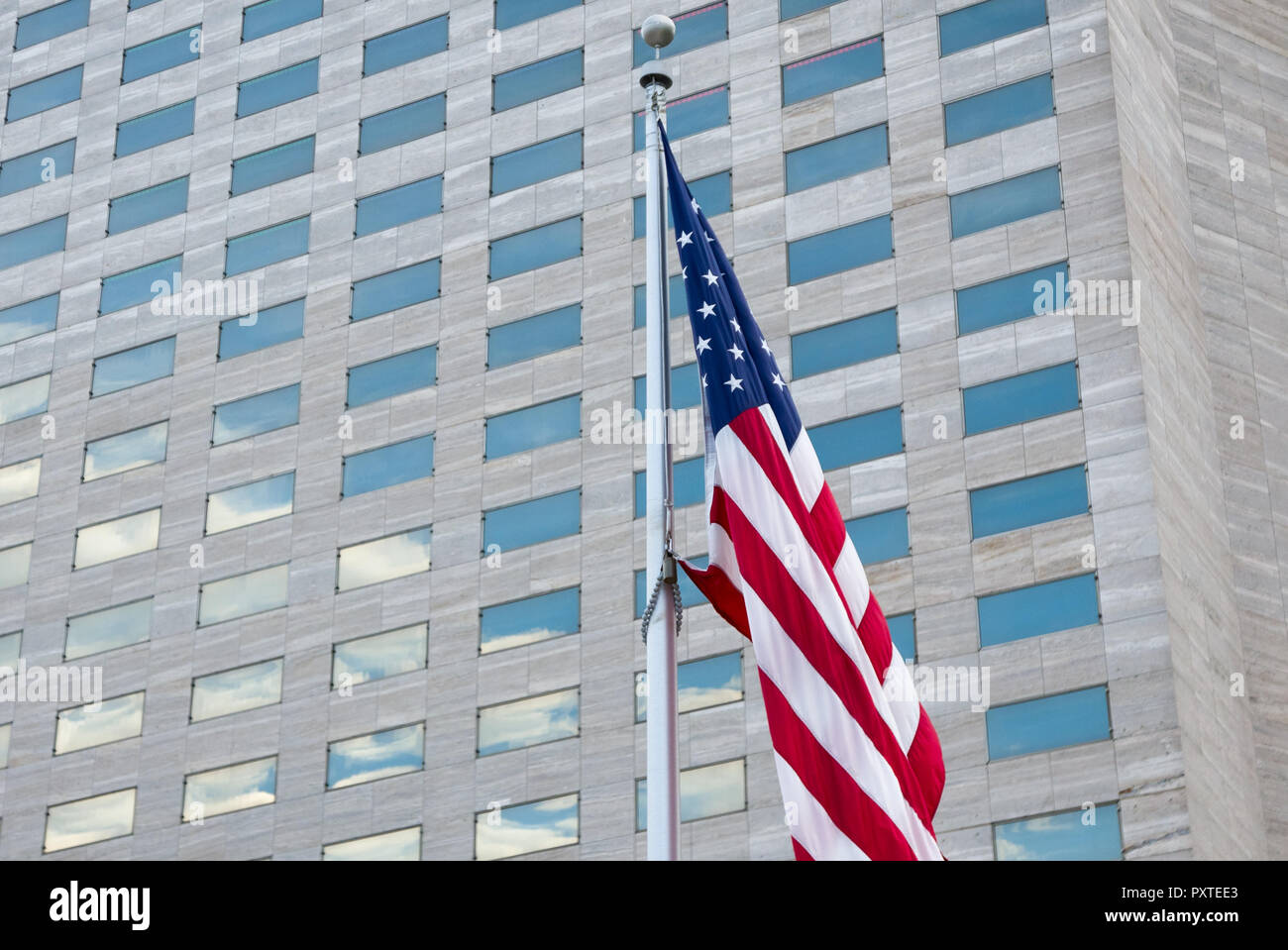 Business background of American flag on modern skyscraper background Stock Photo