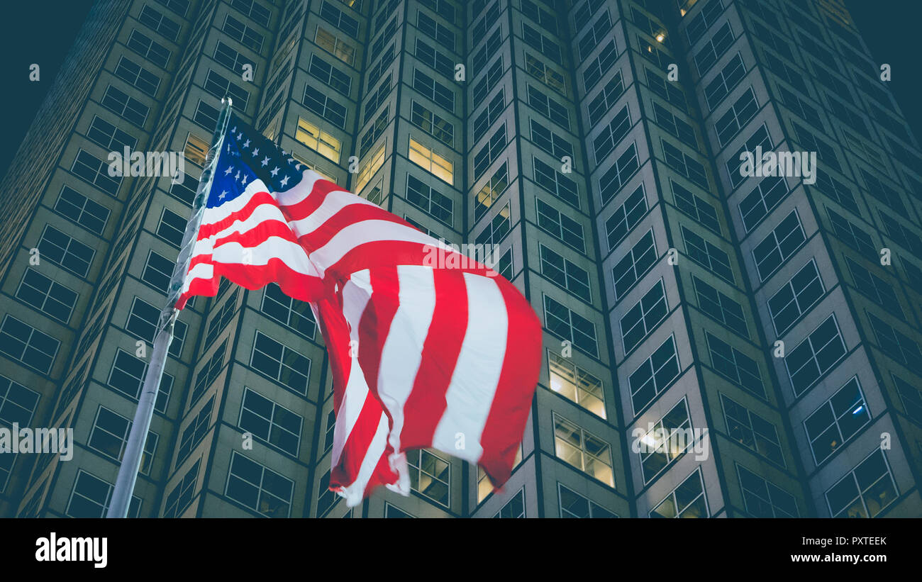 USA flag in front of business building at night, business and economy concept Stock Photo