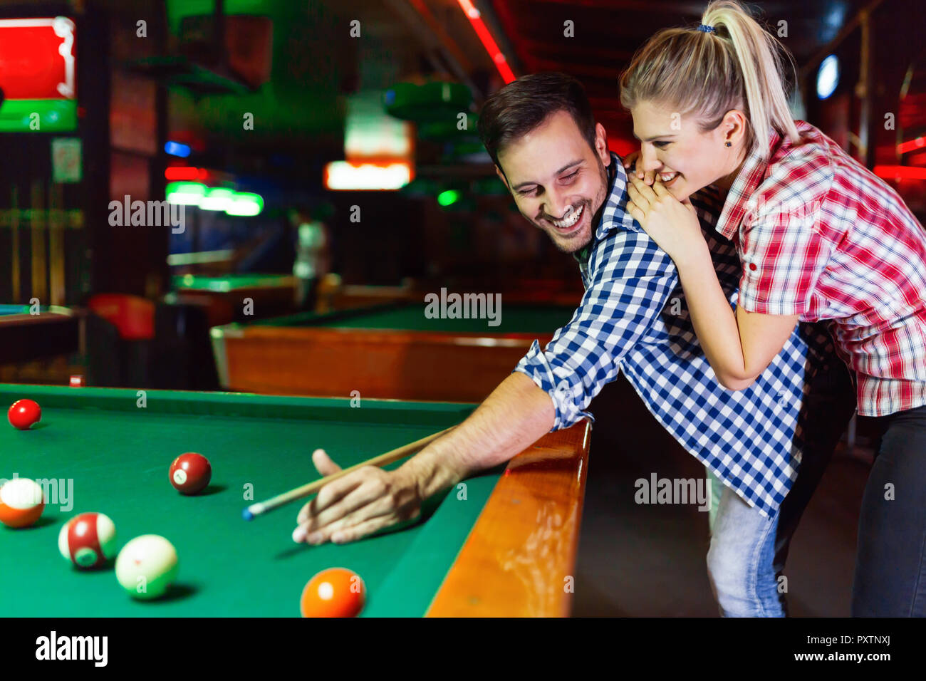 Young couple playing together pool in bar Stock Photo