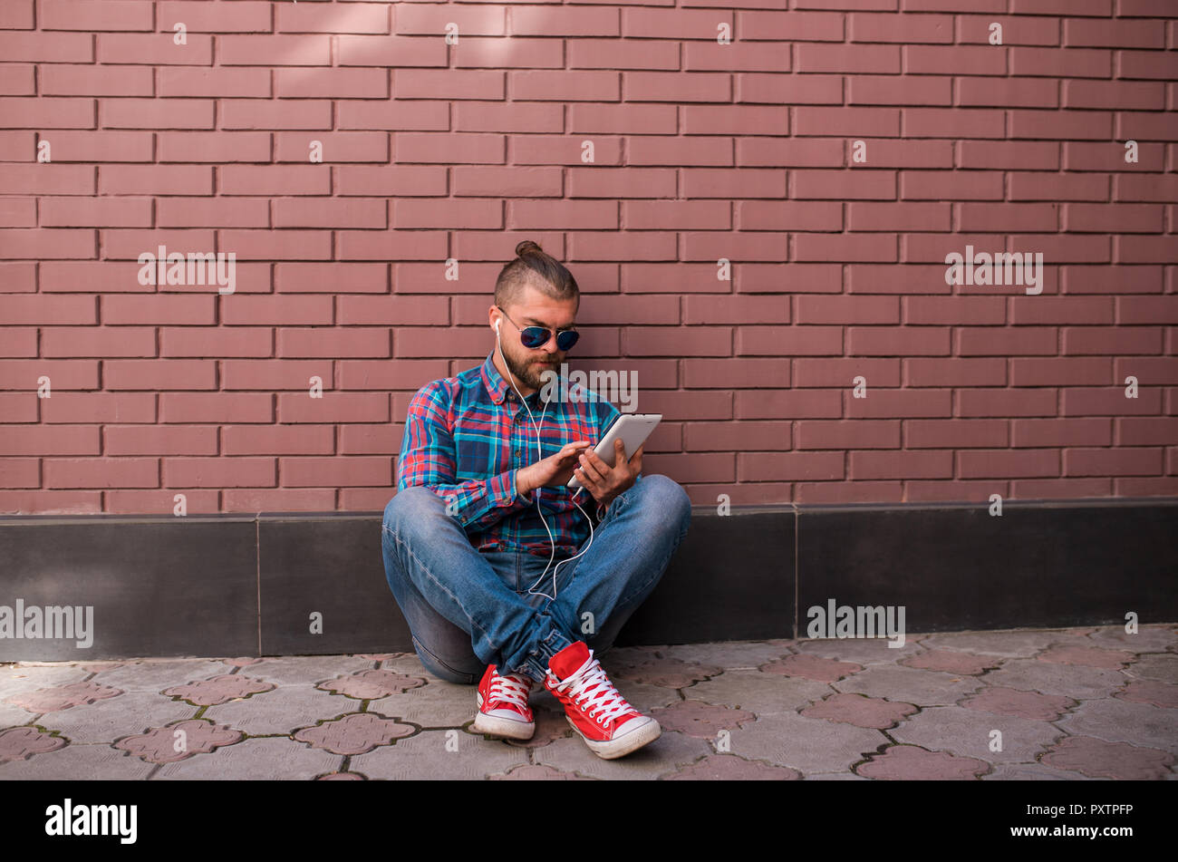 Handsome hipster guy working on digital tablet. Stock Photo