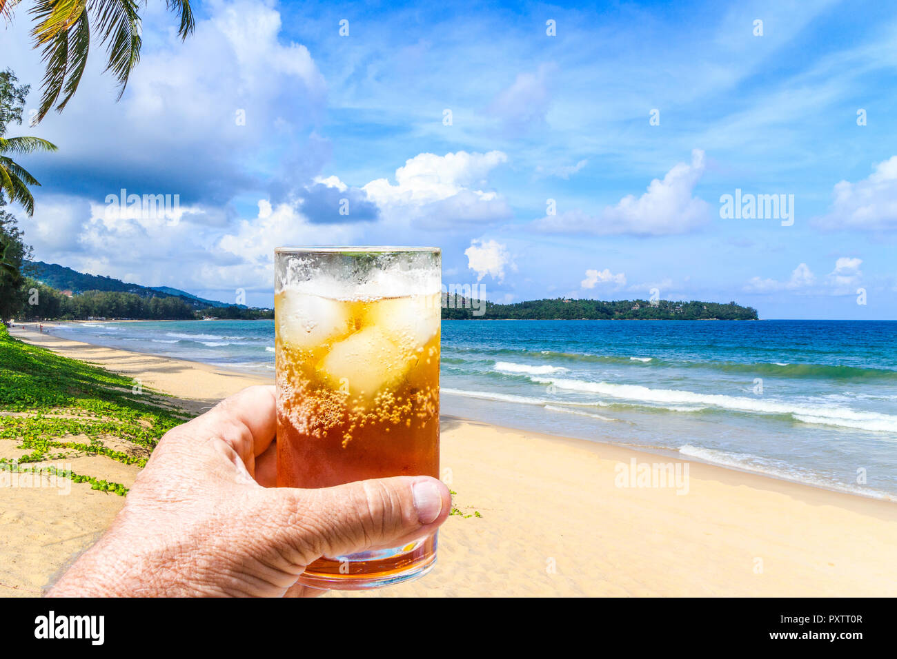 https://c8.alamy.com/comp/PXTT0R/hand-holding-a-rum-and-coke-cocktail-in-glass-with-ice-bang-tao-beach-phuket-thailand-PXTT0R.jpg