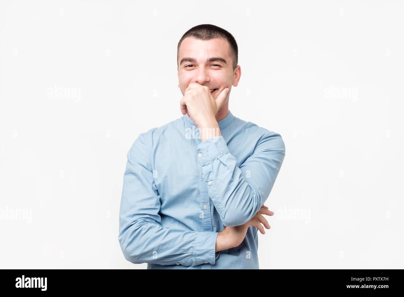 Hispanic young man with laugh face on grey background. Stock Photo