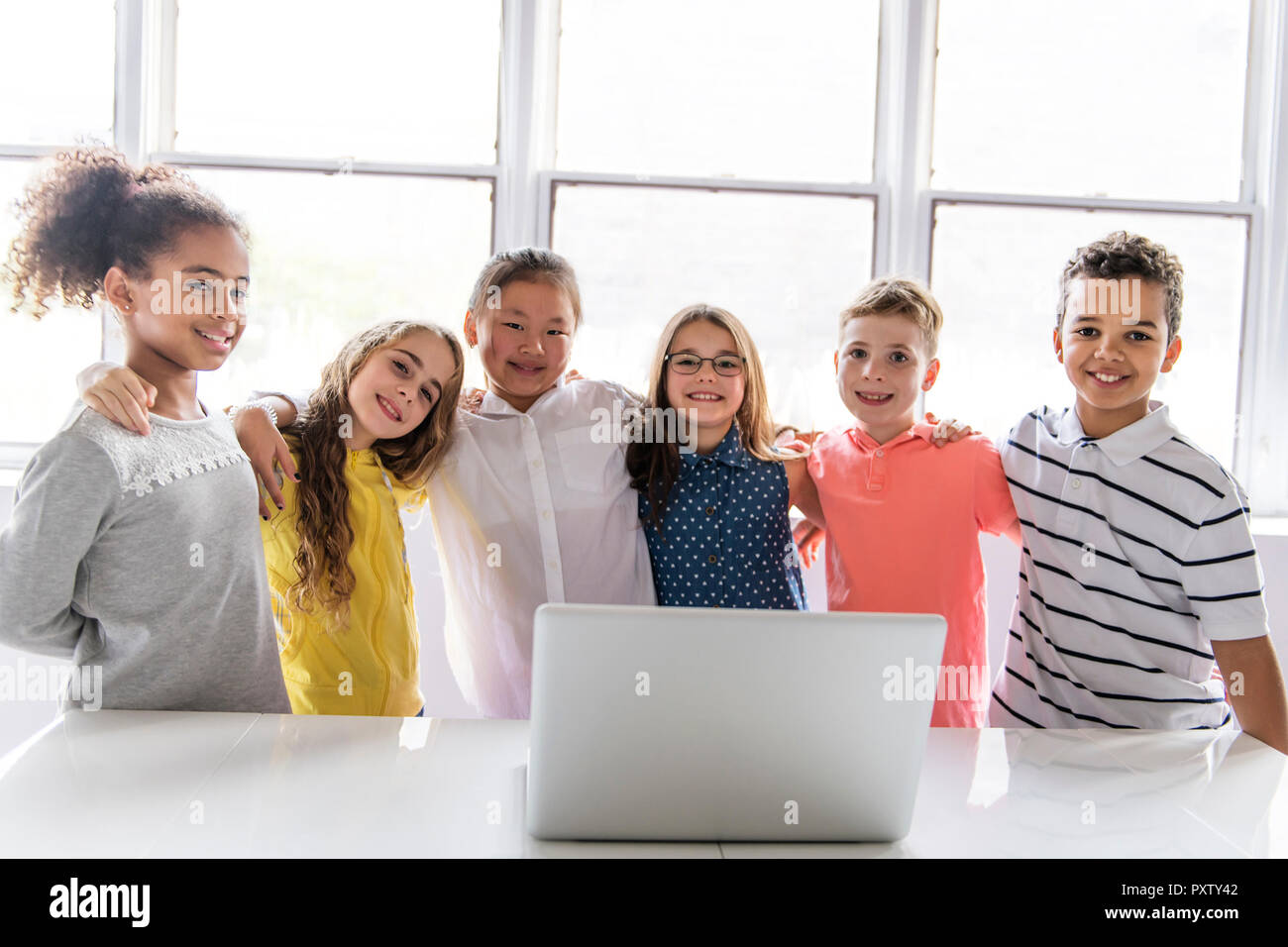 A Group of curious children watching stuff on the laptop screen Stock Photo