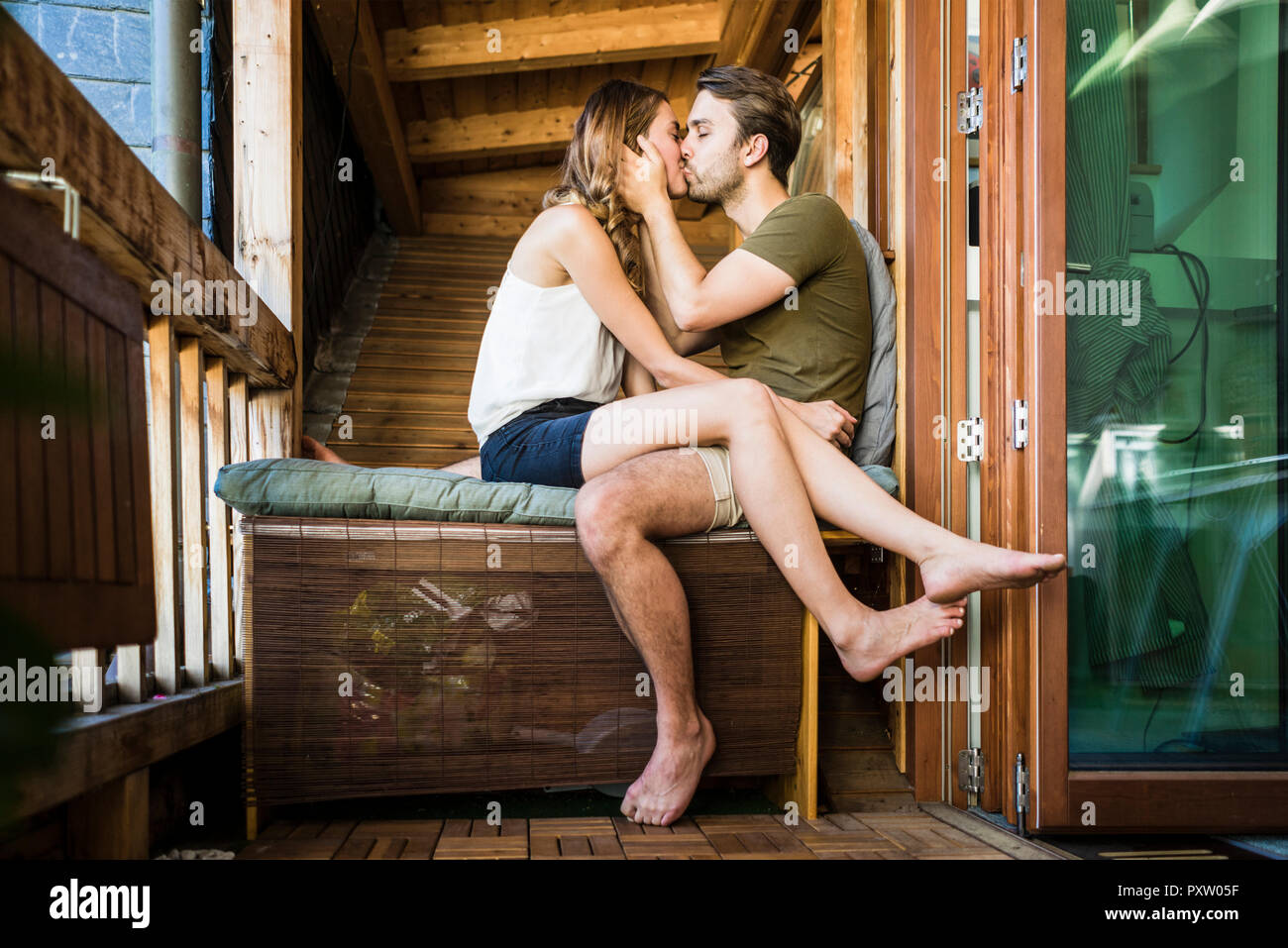 Affectionate couple kissing on balcony Stock Photo