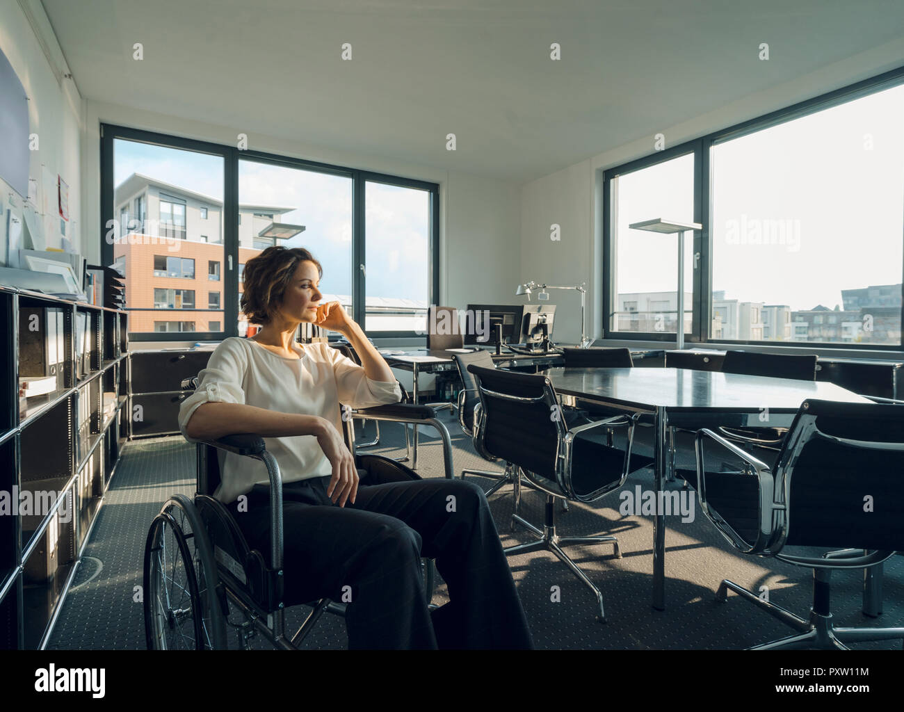 Disabled business woman sitting in wheelchair, smiling Stock Photo