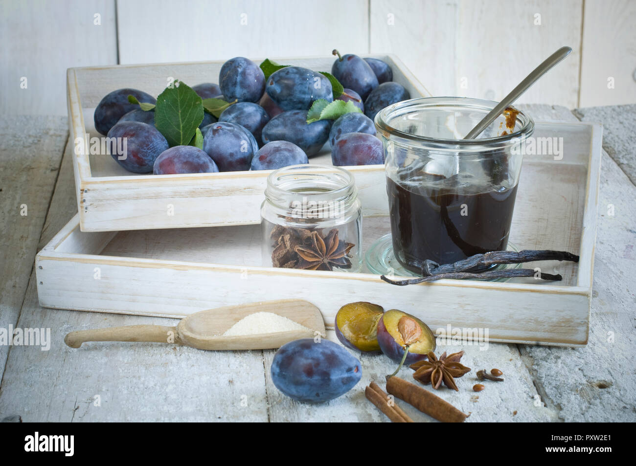 Preserving jar of plum jam, plums  and ingredients on wood Stock Photo