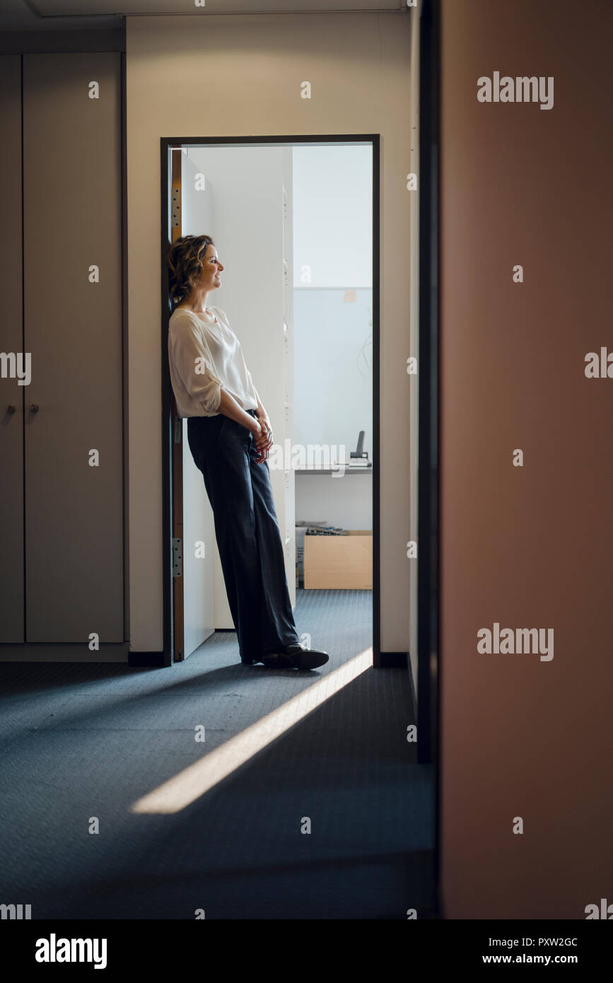 Businesswoman leaning relaxed in door frame of her office Stock Photo Alamy