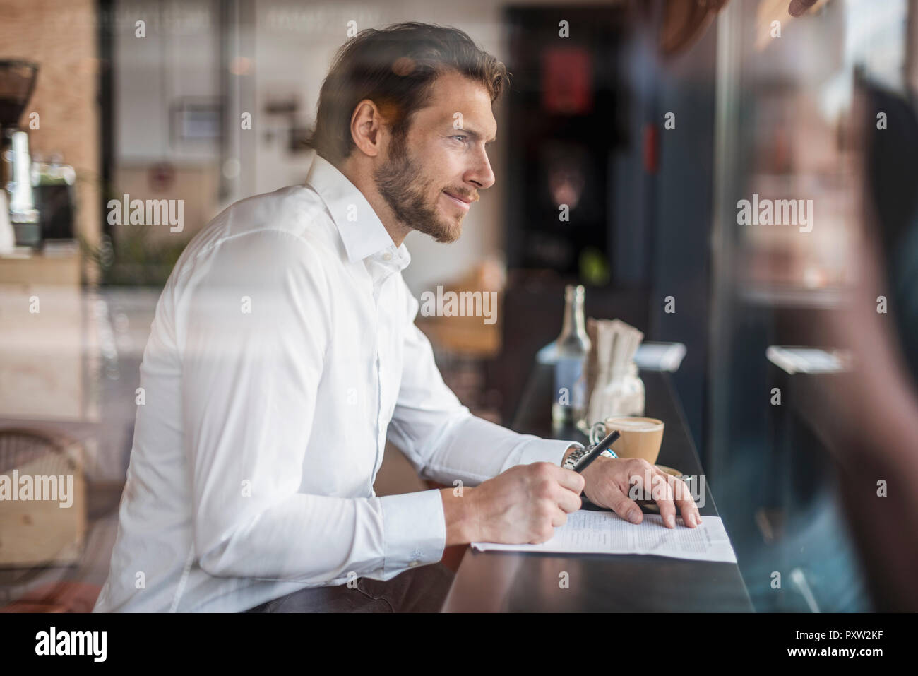 Businessman in a cafe taking notes Stock Photo