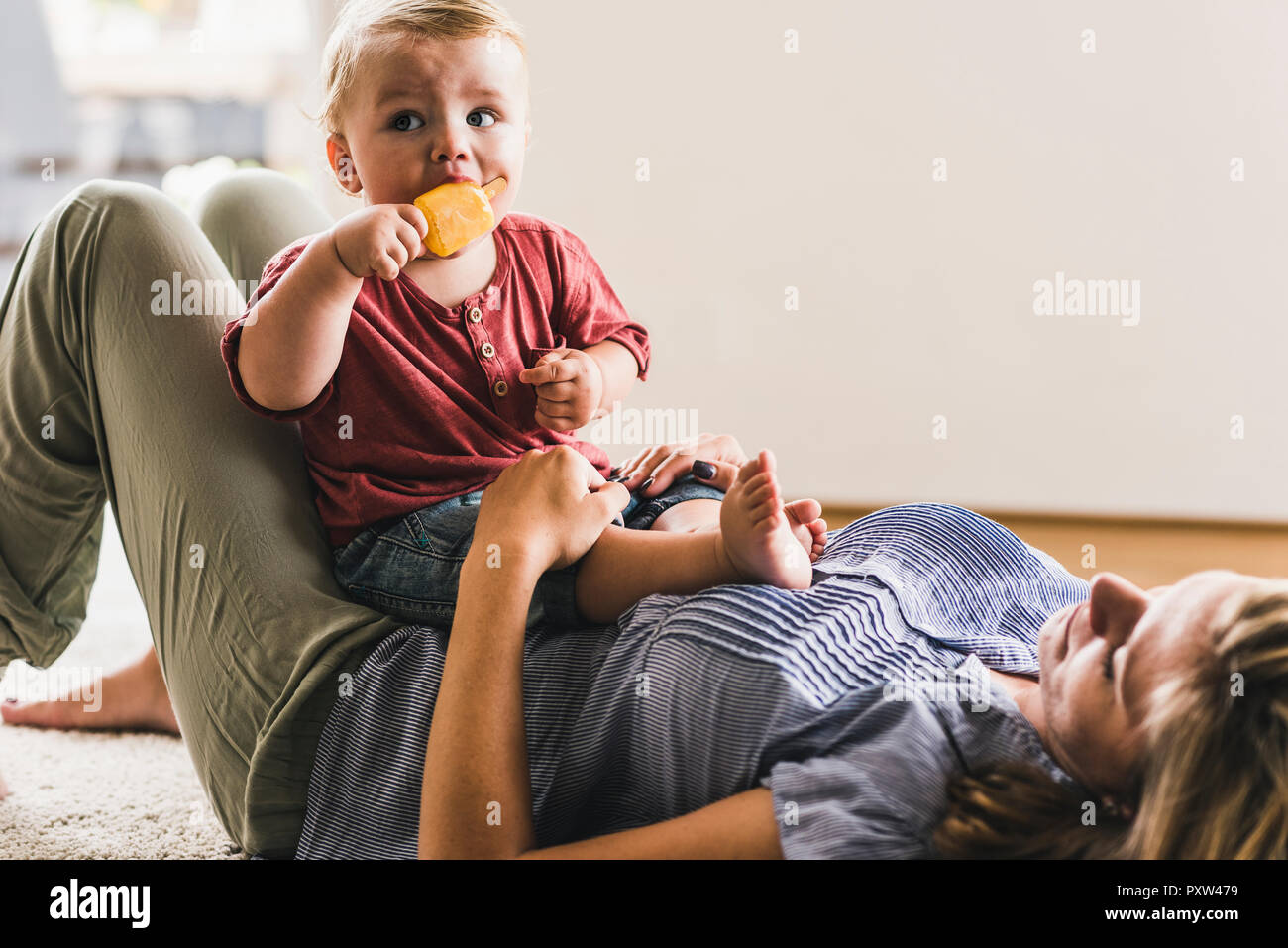 Mother and son at home eating ice lolly Stock Photo