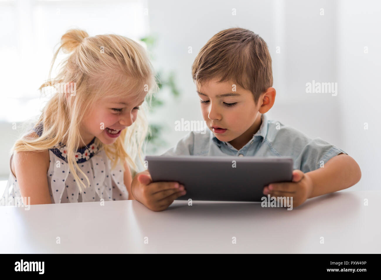 An Adorable brother and sister young child using tablet Stock Photo - Alamy