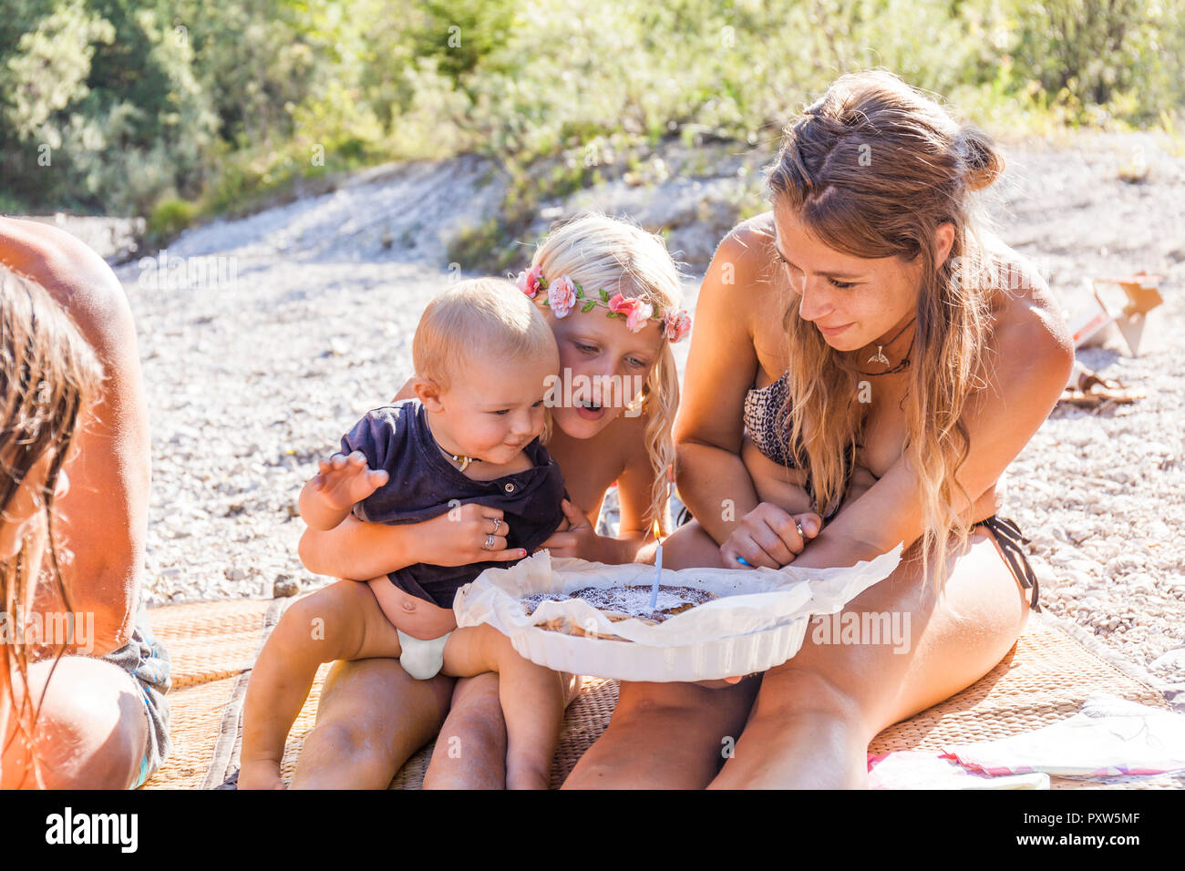 Family celebrating baby boy's first birthday at the riverside Stock Photo