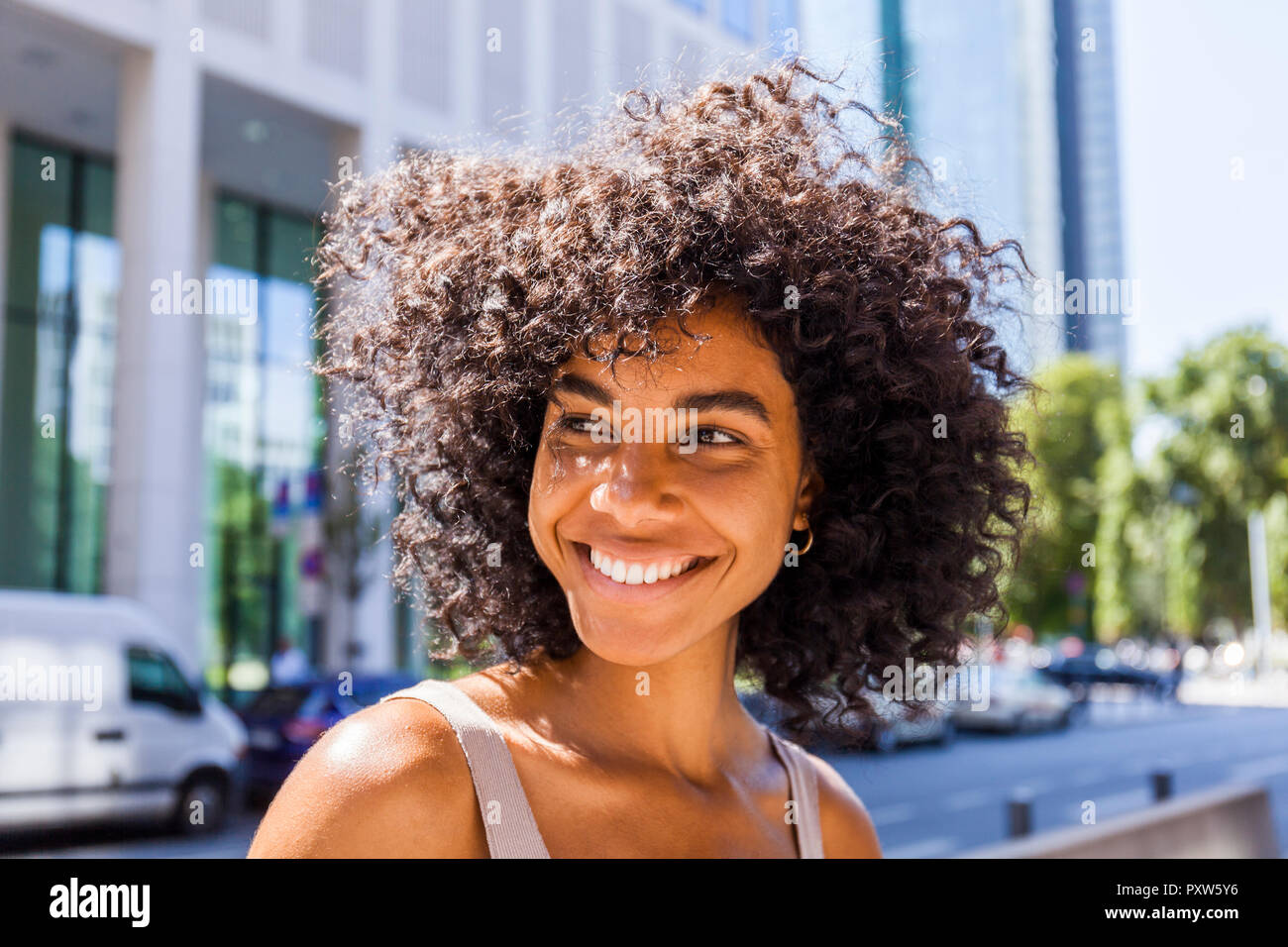 Germany, Frankfurt, portrait of laughing young woman with curly hair Stock Photo