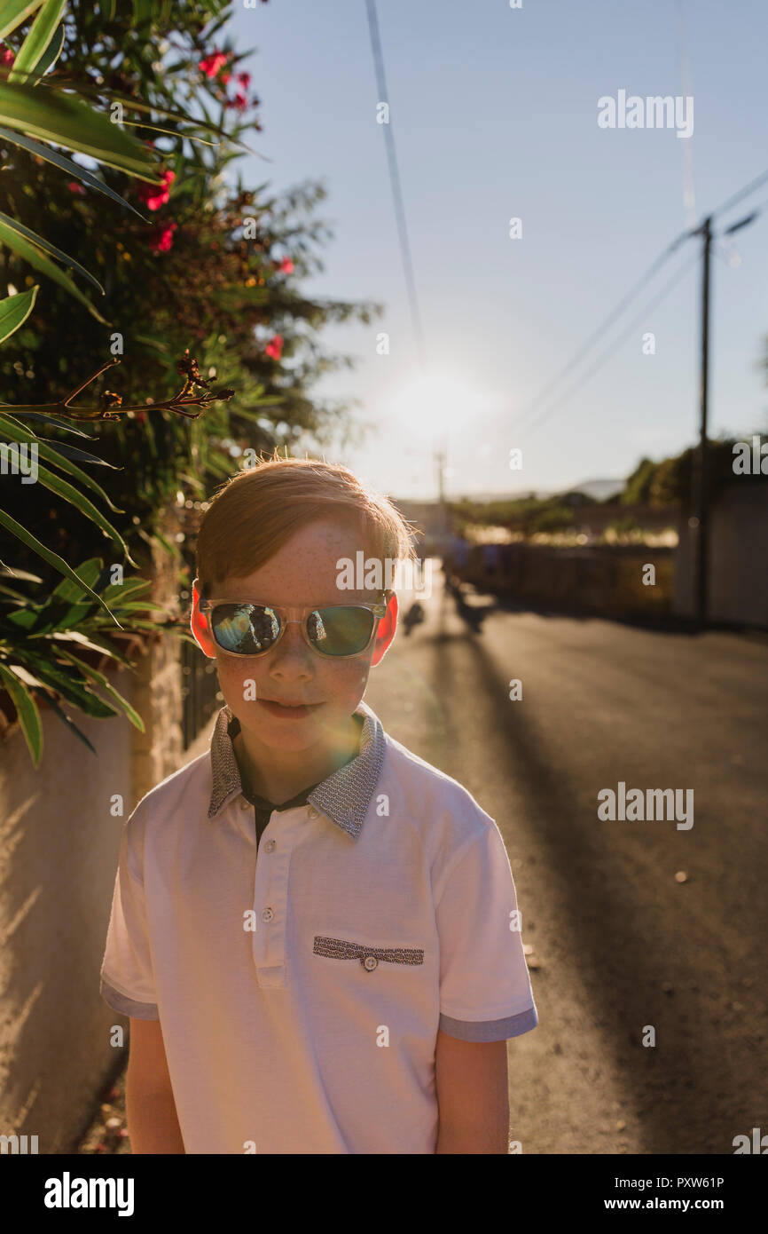 Portrait of boy wearing mirrored sunglasses at evening twilight Stock Photo