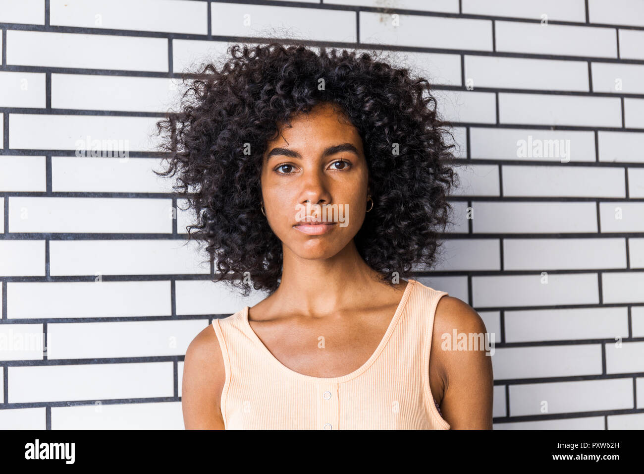 Portrait of serious young woman with curly hair Stock Photo