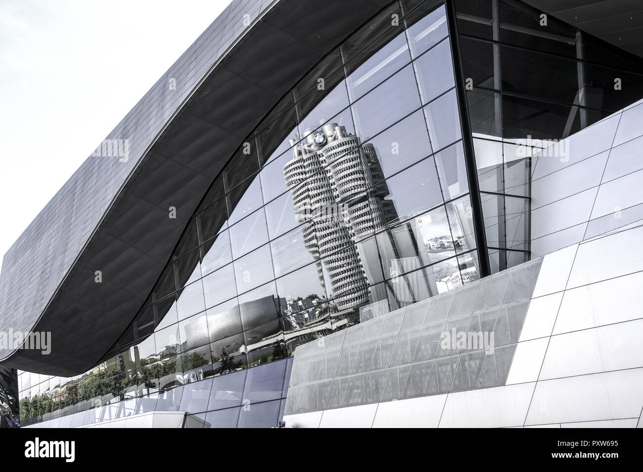 BMW Firmenzentrale spiegelt sich in der Glasfassade der BMW-Welt, München, Bayern, Deutschland, Europa Stock Photo
