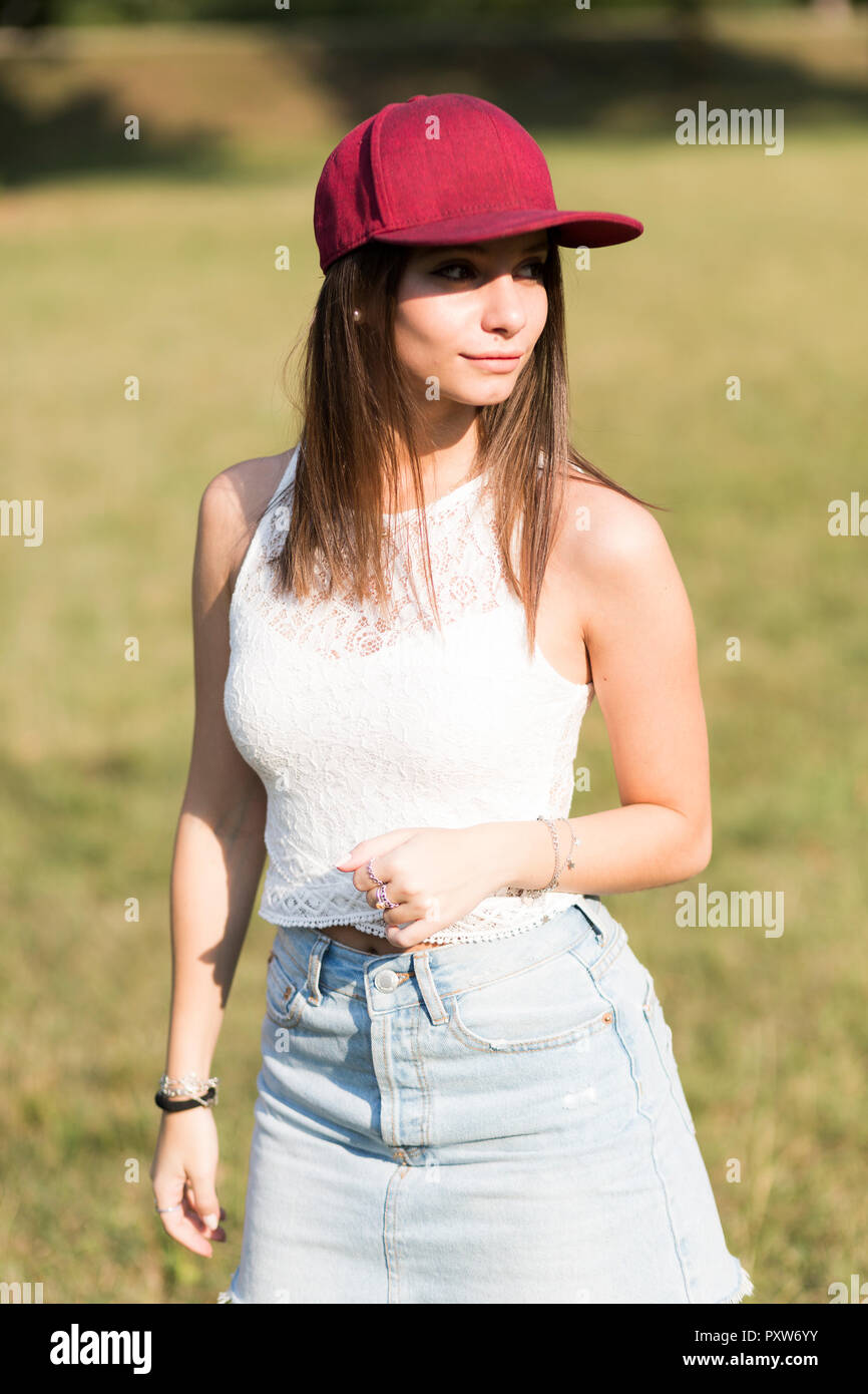 Young woman wearing baseball cap standing on a meadow Stock Photo