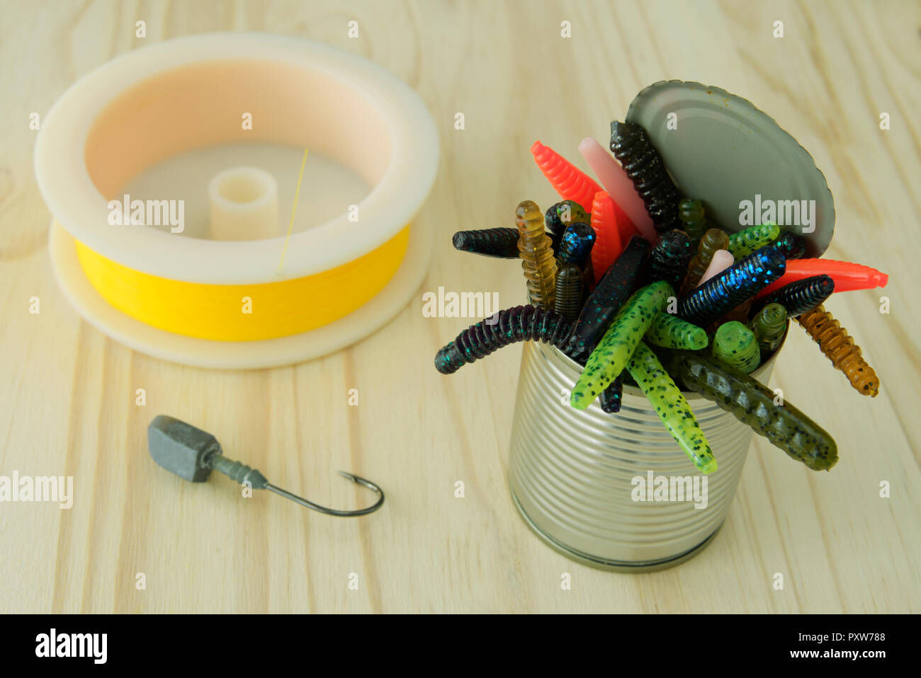Tin can of colourful artificial plastic worms with yellow fishing
