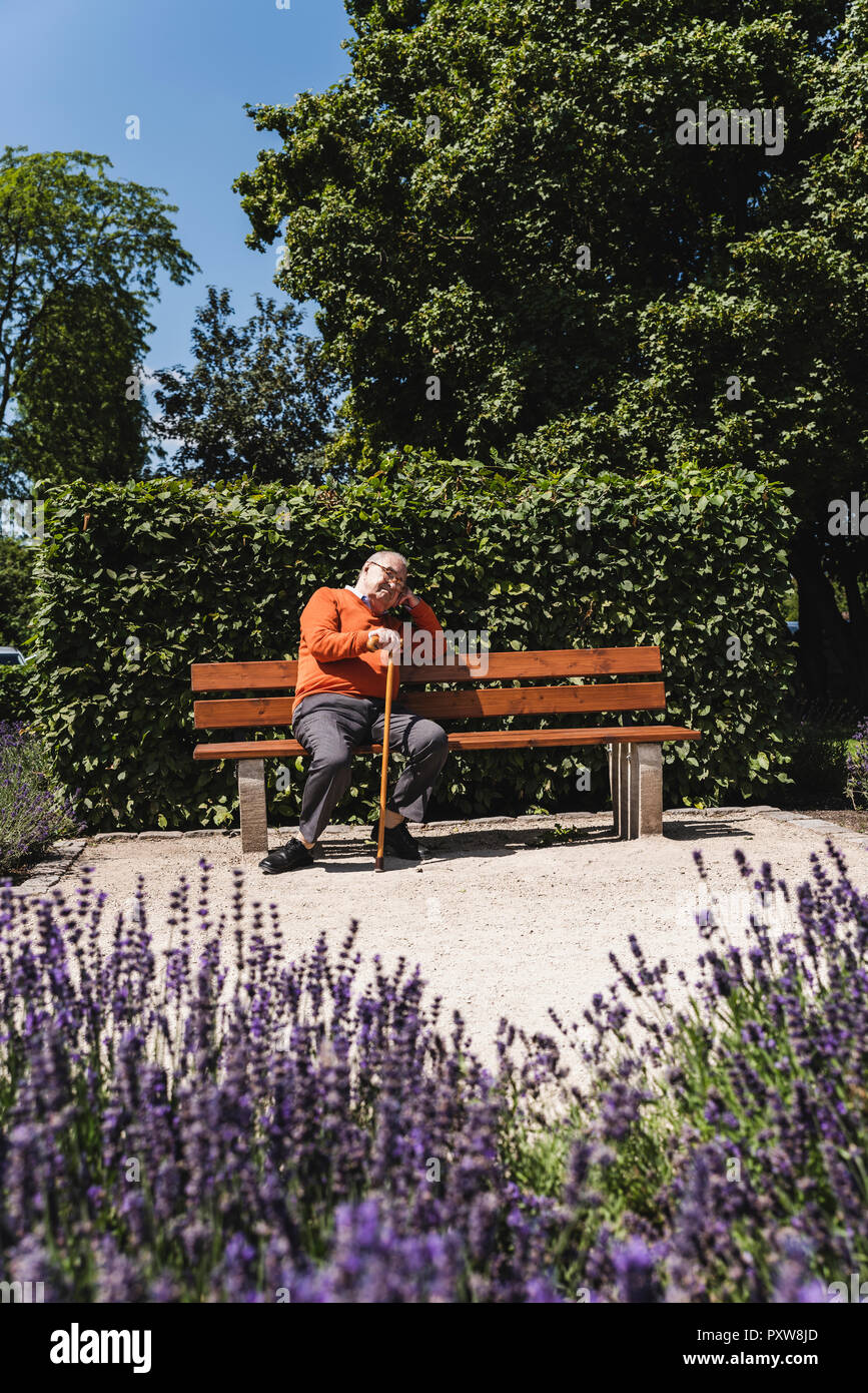 Senior man sitting on park bench, waiting Stock Photo