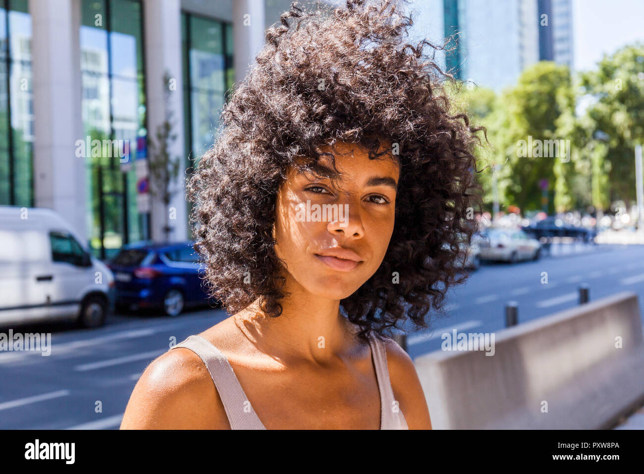 Germany, Frankfurt, portrait of young woman with curly hair Stock Photo