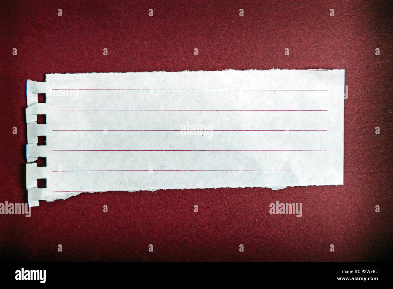 Turn notebook paper on dark red background Stock Photo