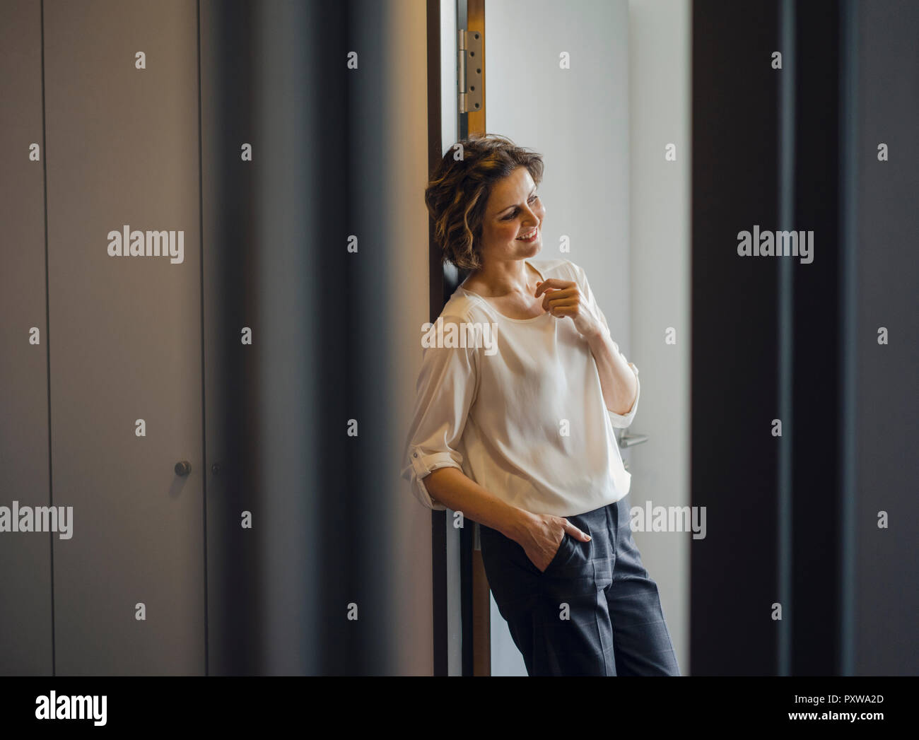 Businesswoman leaning relaxed door frame office hires stock photography and images Alamy