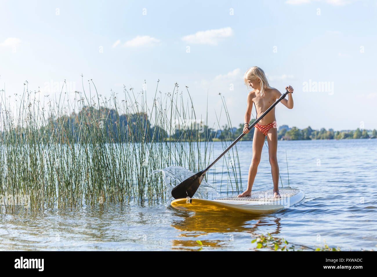 Young girl stand up paddle surfing Stock Photo