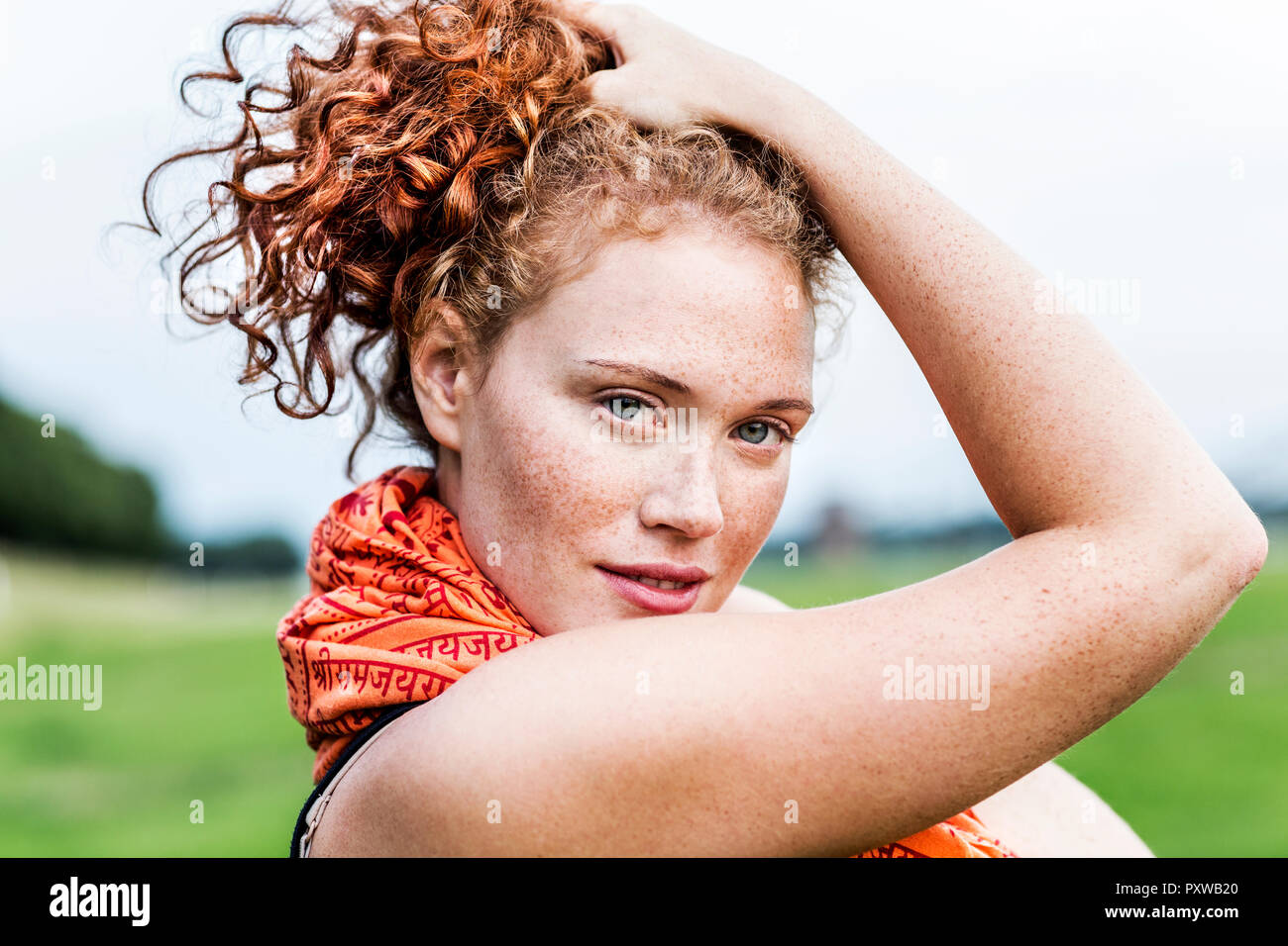 Portrait of freckled young woman with curly red hair Stock Photo