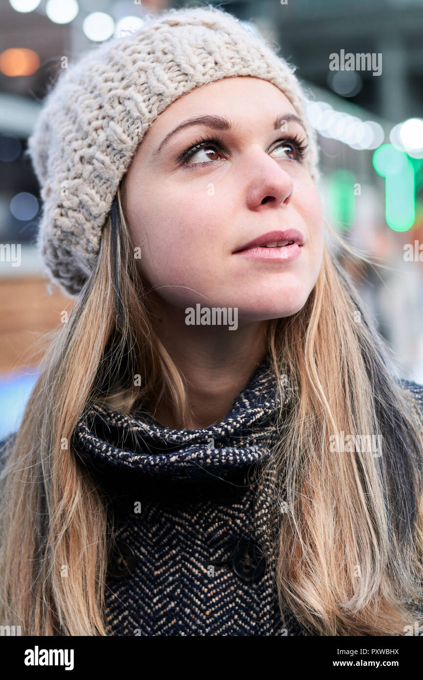 Portrait of pensive blond young woman wearing wool cap in winter Stock Photo
