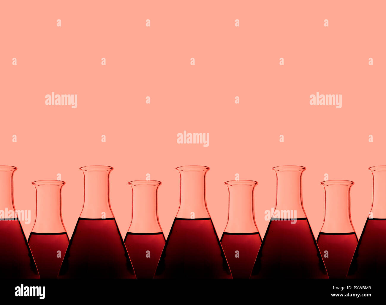 Row of test tubes with liquid, red background Stock Photo