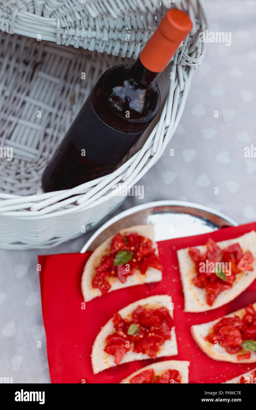 Bruschetta and bottle of wine on picnic blanket Stock Photo