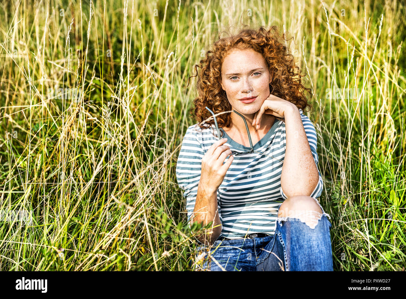 Young of woman sitting on a meadow Stock Photo
