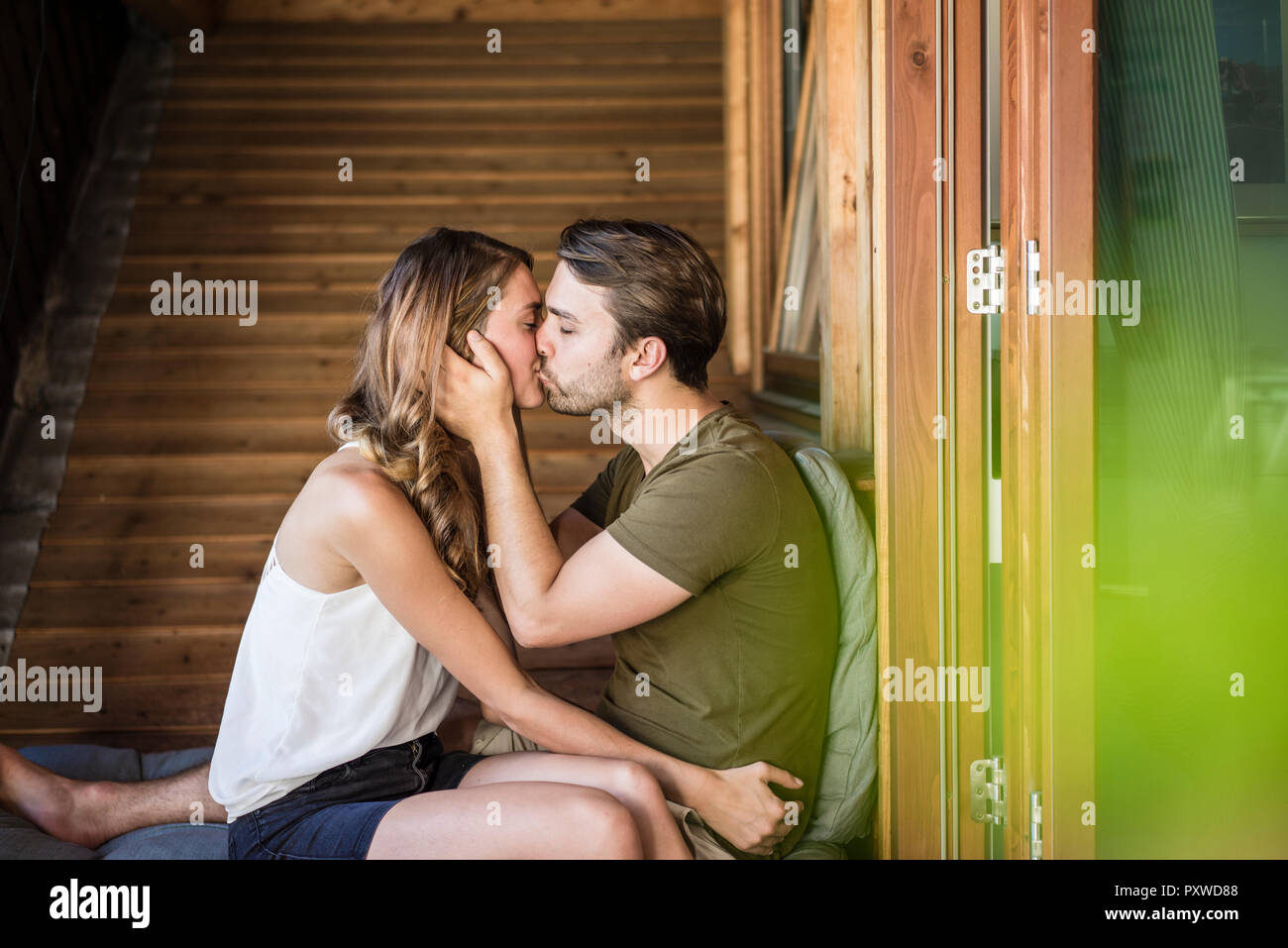 Affectionate couple kissing on balcony Stock Photo