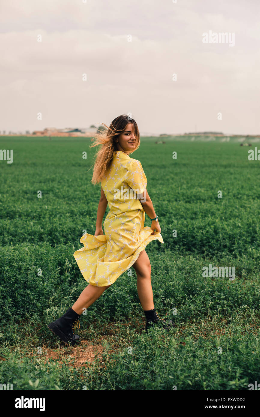 Young woman walking in a green field Stock Photo - Alamy