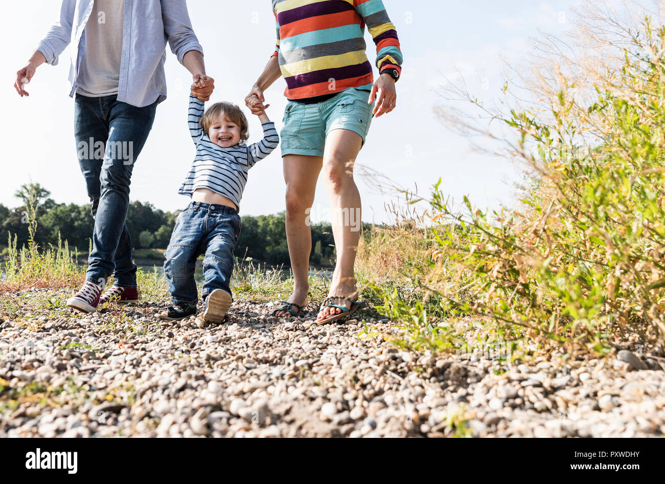 Happy family walking at the riverside on a beautiful summer day Stock Photo