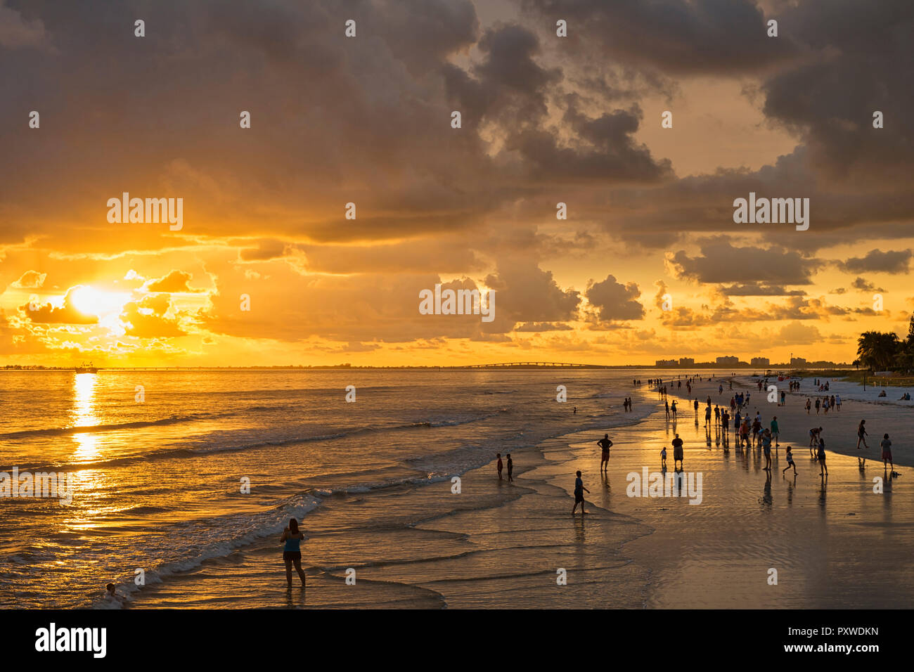 United States of America, Florida,  Fort Myers, silhouettes of Fort Myers Beach and tourists with a huge rain cloud above during sunset Stock Photo