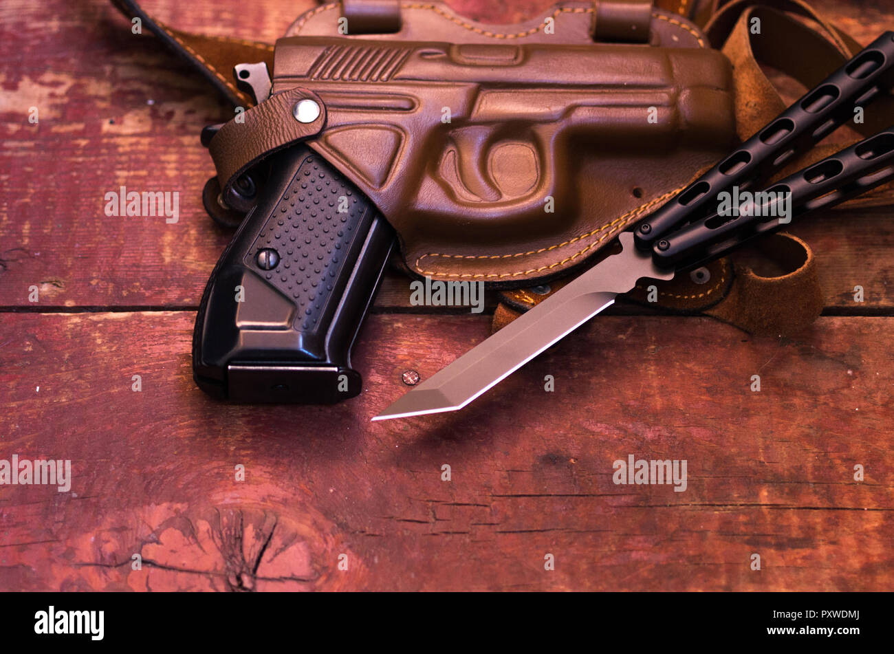 A knife and a gun. A pistol in a leather holster. View from above Stock