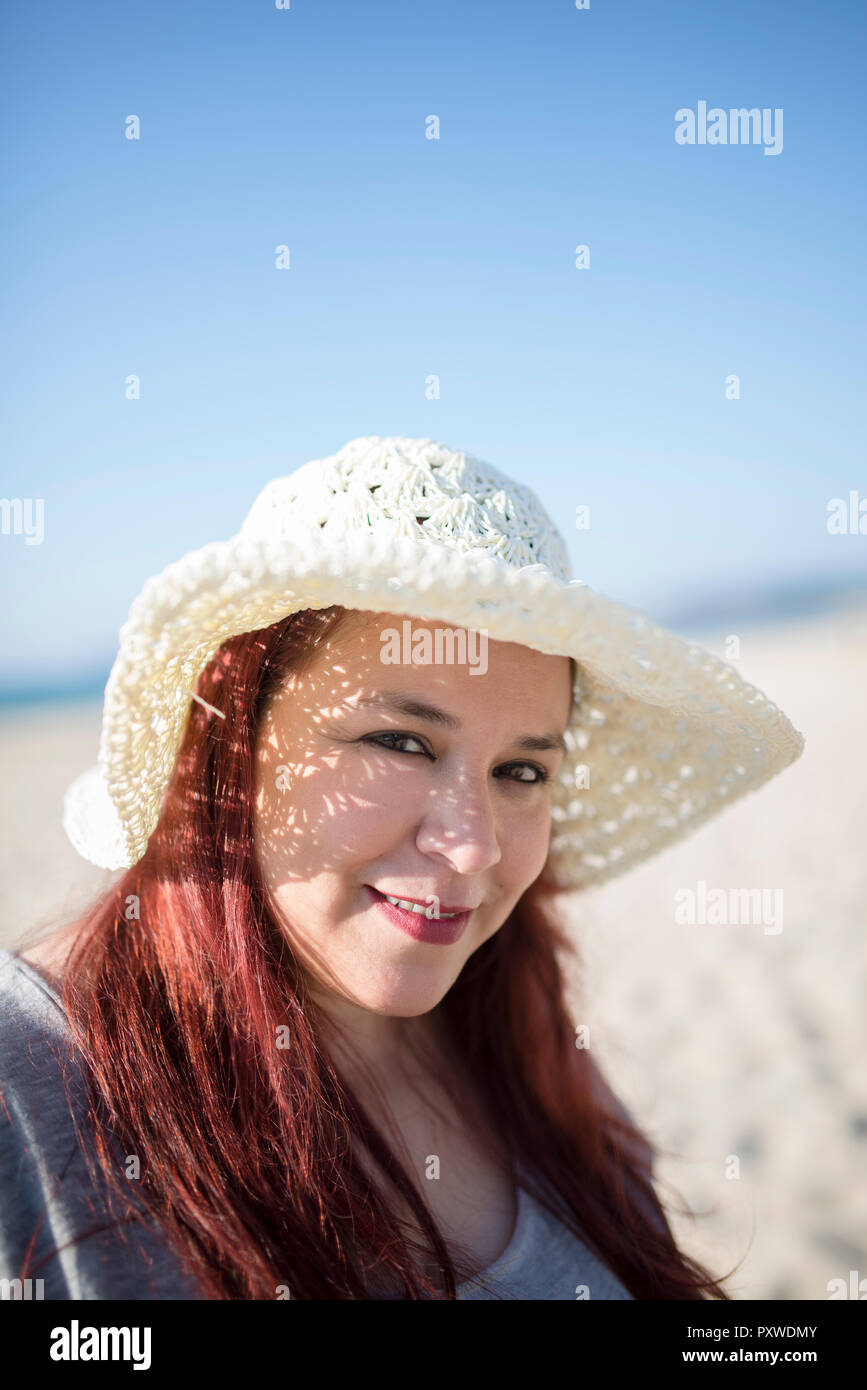 Portrait of smiling woman wearing summer hat on the beach Stock Photo ...