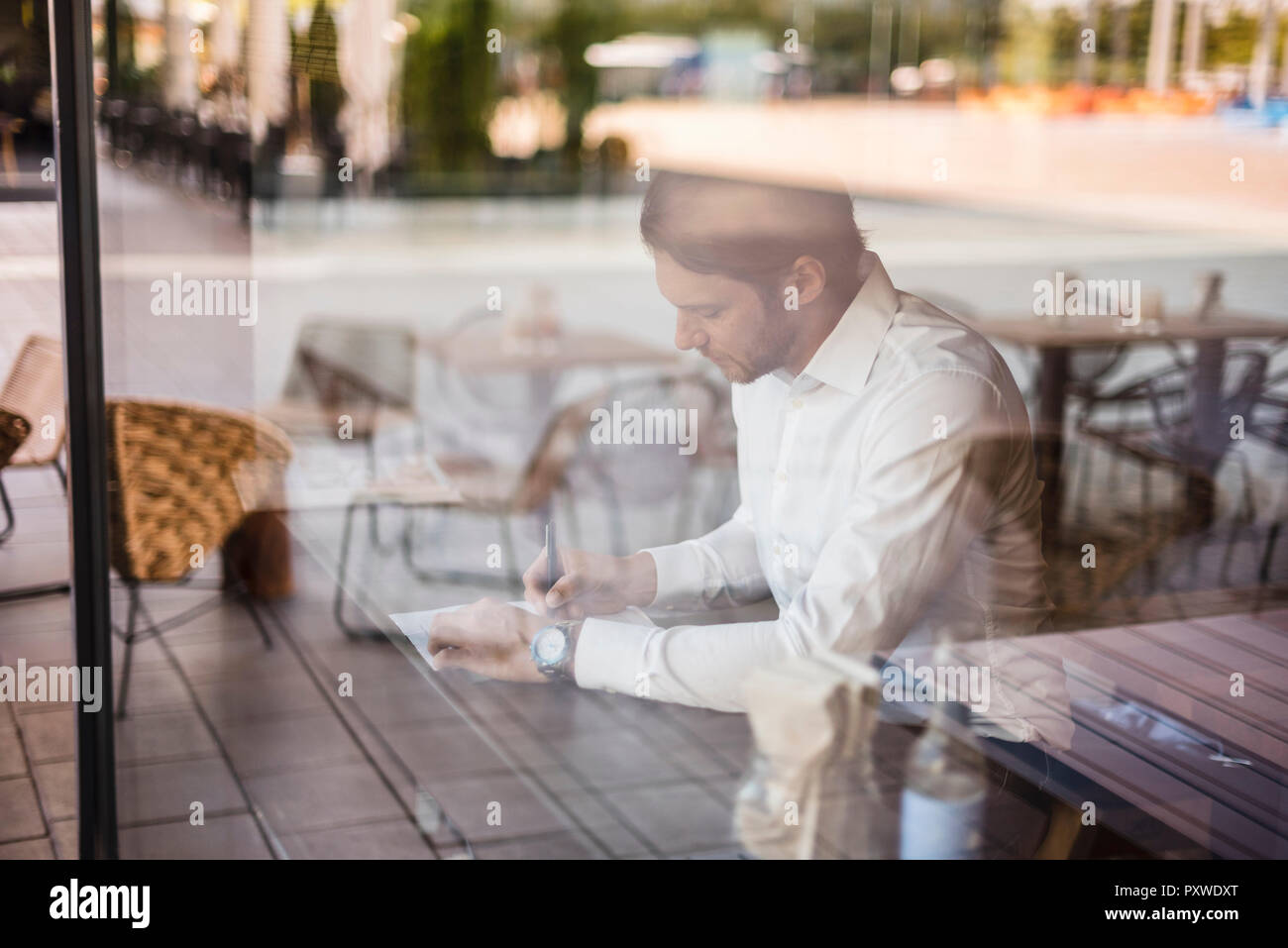 Businessman in a cafe taking notes Stock Photo