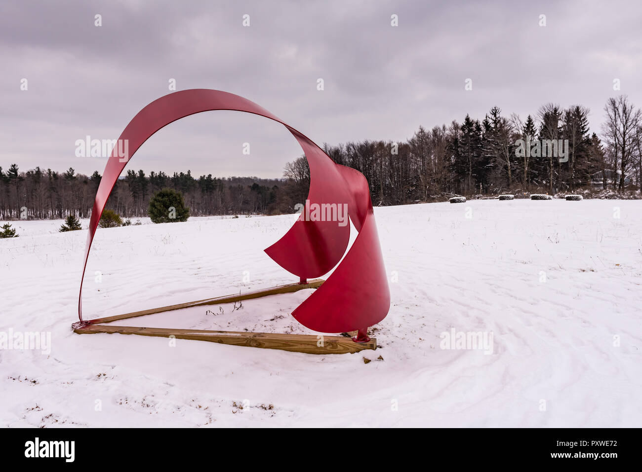 Whales Tail, a red aluminum sculpture by Miriam Nelson, punctuates winter landscape at the Stone Quarry Hill Art Park in the town of Cazenovia in Madi Stock Photo