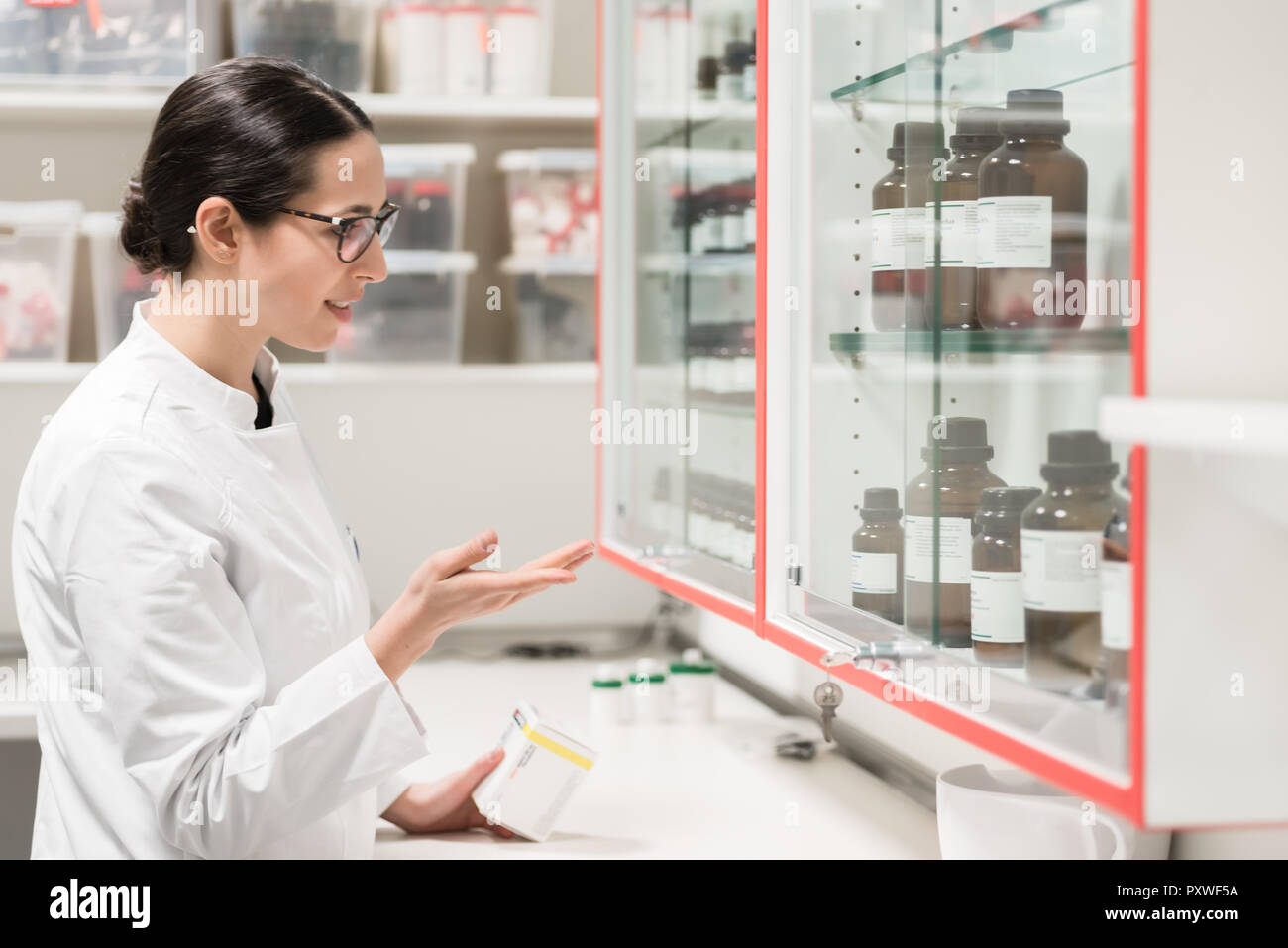 Pharmacist checking a chemical pharmaceutical substance in a modern drugstore Stock Photo
