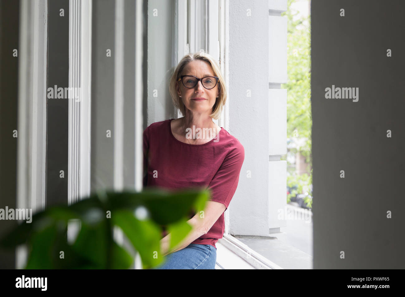 Portait of confident mature woman at the window Stock Photo