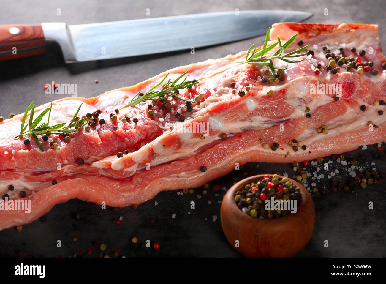 Raw ribs with spices on a stone background with empty space for text Stock Photo